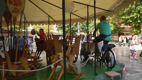 A man pedaling during the day for a carousel rides Stock Footage 141170050