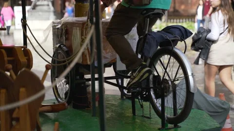 A man pedaling during the day for a carousel rides Video stock 141170070