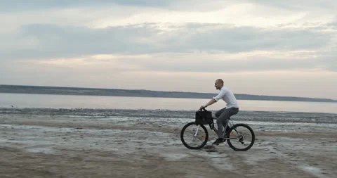 Man pedals slowly along soft waves appreciating warm horizon Stockbeeldmateriaal 323964982