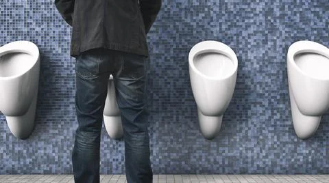 The man is peeing. Back view. Public toilet. Men's health topics. Foto stock
