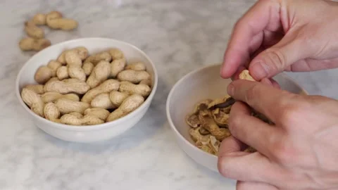 Man peeling and eating some peanuts Stock Footage