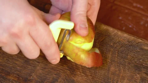 Man peeling an apple in the kitchen Stockbeeldmateriaal 251450531