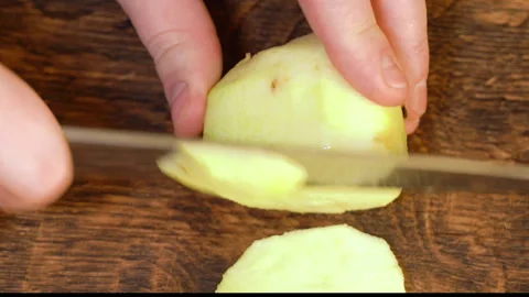 Man peeling an apple in the kitchen Stockbeeldmateriaal 251450718