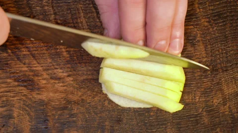 Man peeling an apple in the kitchen Stockbeeldmateriaal 251450777