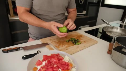 Man peeling an avocado in a modern kitchen 스톡 동영상 346529496