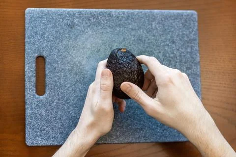 A man peeling an avocado Stock Photos
