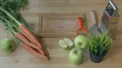 Man peeling the carrot on the kitchen table view from above. Stock Footage 75623012