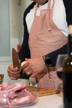 Man peeling onion in kitchen preparing meal Foto stock