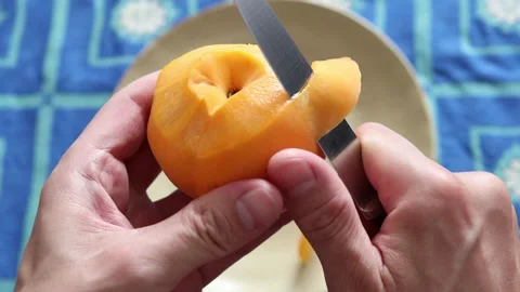 Man peeling a peach with a knife 库存影片 159145919