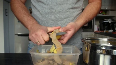 Man peeling potato with knife in kitchen Stock Footage 122083230