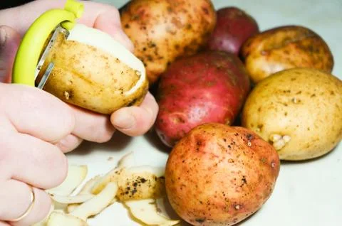 Man peeling potatoes Stock Photos