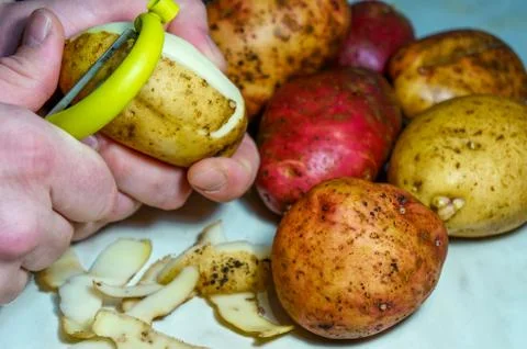 Man peeling potatoes Stock Photos