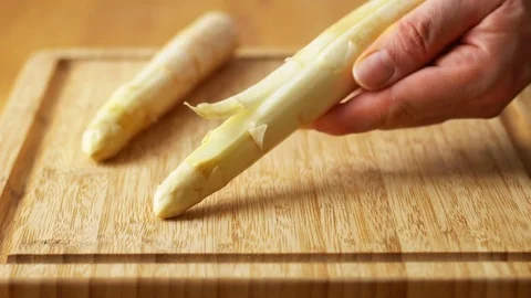 Man peeling a white asparagus with a vegetable peeler Stock Footage 74795234