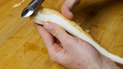 The man peels the parsley root. Close shot. 4K 스톡 동영상 128594974