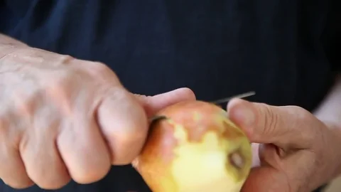 Man peels a pear Stock Footage 83516749