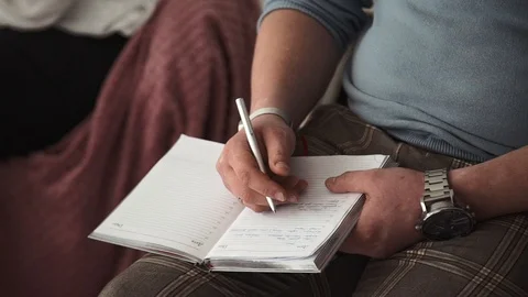 A man of people is writing in a notebook Stock Footage 105484023