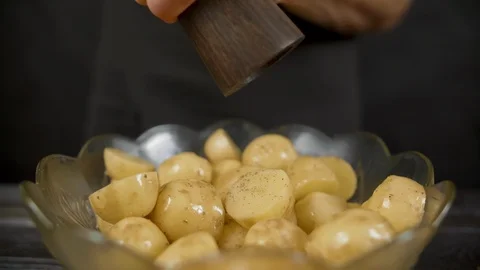 Man pepper potato from pepper pot in the dark kitchen Stock Footage 112736551