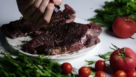 A man peppers a beef steak. Pepper steak. Slow Motion Stock Footage 191111745