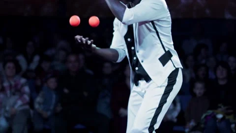 Man performer juggling vibrant orange balls, stage show for audience enjoyment, Stock-Footage 340387658
