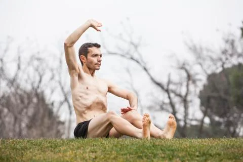 Man performing abdominal exercise sit down on the grass Stock Photos