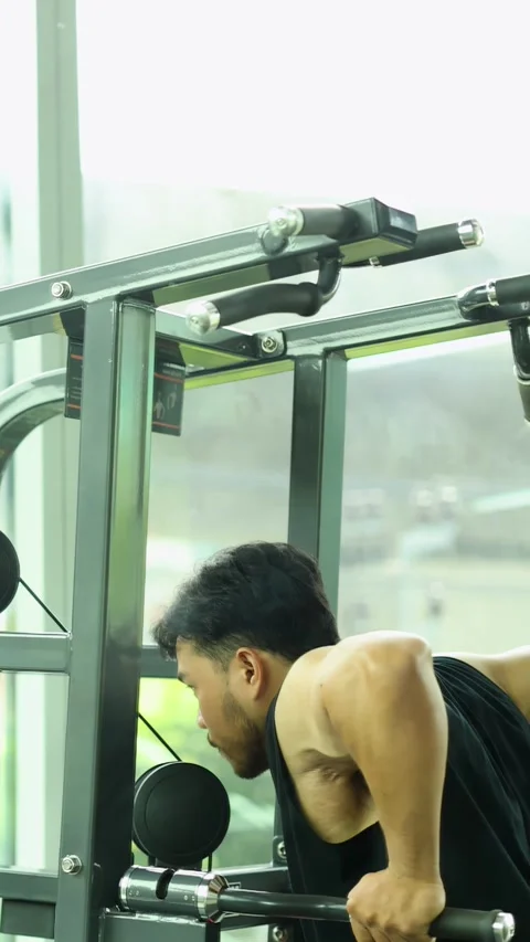 Man Performing Assisted Pull-Up Exercise in Modern Gym Stock Footage 325025389