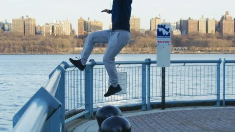 Man performing back flip stunt at promenade Stock Footage 99753715