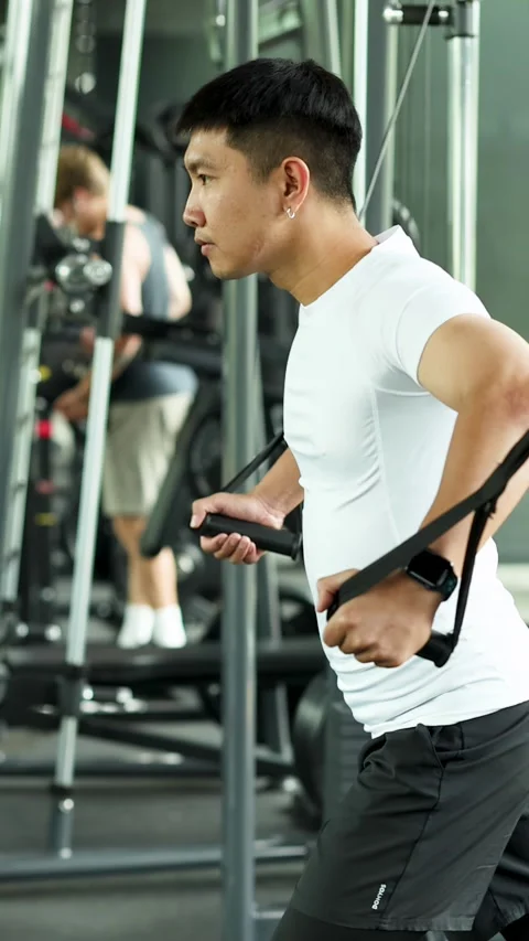 Man Performing Cable Chest Fly Exercise in Gym Stock Footage 318633742