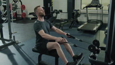Man Performing Cable Rows on Rowing Machine during Workout in Gym Video stock 285643894