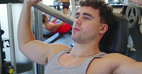 Man Performing Chest Press Exercise in Gym Stock Footage 323774613