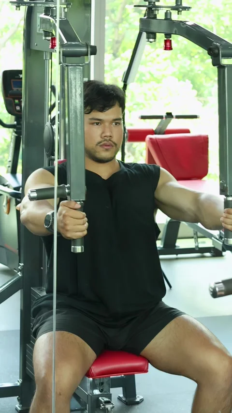 Man Performing Chest Press Exercise on Gym Machine Stock Footage 328565435