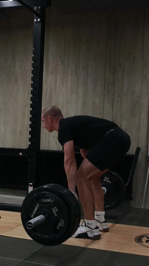 Man performing deadlift exercise with barbell in gym Stock Footage 327722330
