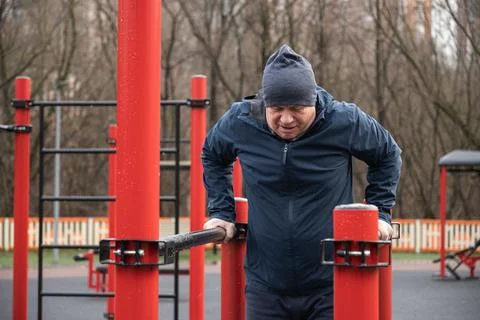 Man Performing Dips on Parallel Bars Outdoors. Training Outdoors Stock Photos