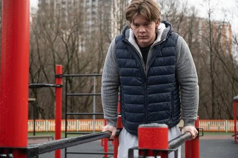Man Performing Dips on Parallel Bars Outdoors. Training Outdoors Foto stock