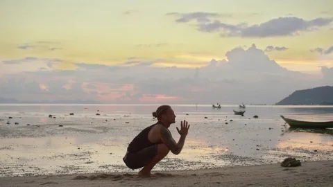 Man performing handstand on the beach at sunset Stock Footage 74905562