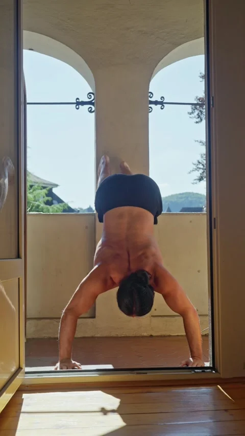 A man is performing an impressive upsidedown pushup in a beautiful, scenic Video stock 312475934
