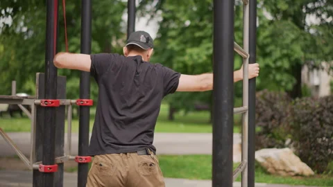 Man performing isometric grip in park, Rear view of man doing strength drill Stock Footage 324756939