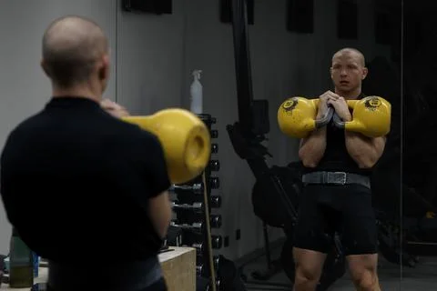 Man performing kettlebell clean exercise in gym, strength training Stock Photos
