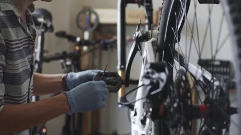 Man is performing maintenance on his mountain bike Stock Footage 277968506