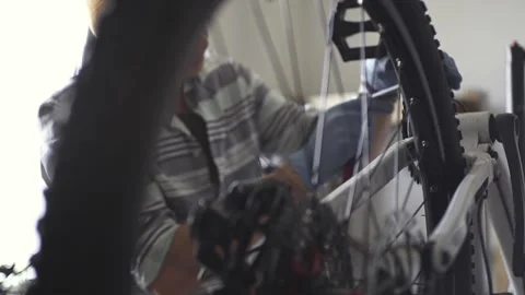 Man is performing maintenance on his mountain bike Stock Footage 277968541