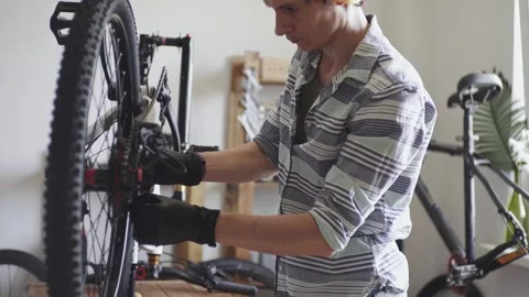 Man is performing maintenance on his mountain bike Stock Footage 277968542