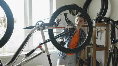 Man is performing maintenance on his mountain bike. Stock Footage 305641914