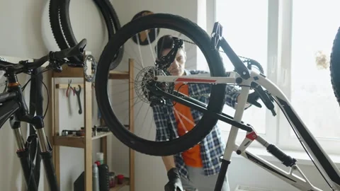 Man is performing maintenance on his mountain bike. Stock Footage 305641958