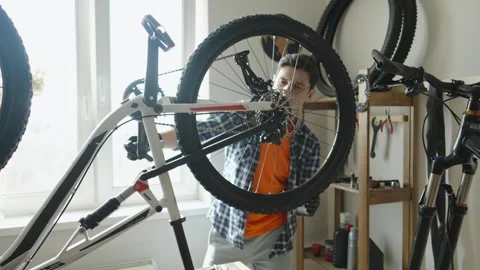 Man is performing maintenance on his mountain bike. Stock Footage 305642132