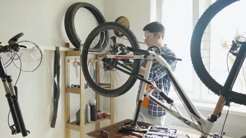 Man is performing maintenance on his mountain bike. Stock Footage 305642207