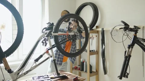 Man is performing maintenance on his mountain bike. Stock Footage 305642469
