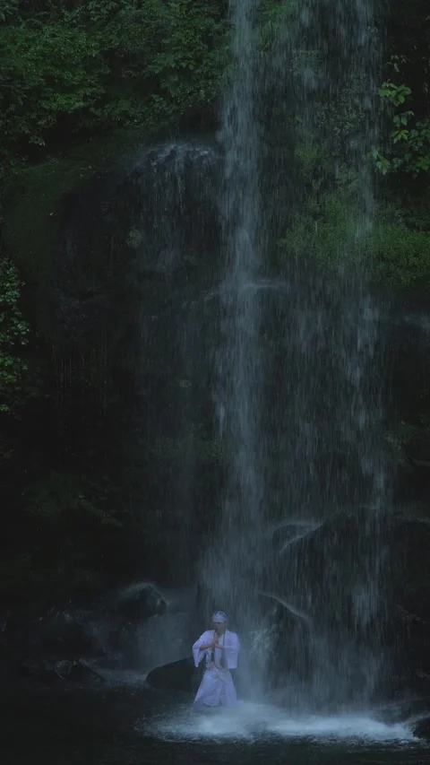 Man performing meditation under Yuhi no taki waterfall Stock Footage 342084816