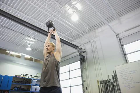 Man performing overhead kettlebell throws Fotos de archivo