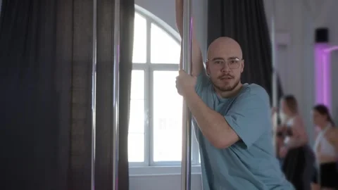 A man is performing pole dancing in a dance studio. Stock Footage 305493927