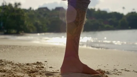Man performing prayer pose yoga on beach at sunset Stock Footage 74775520