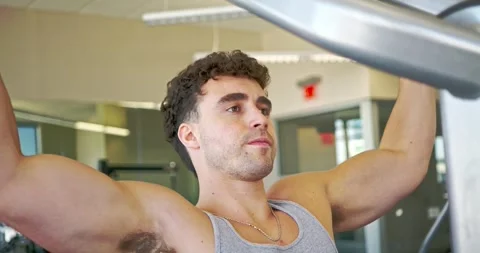 Man Performing Pull-Ups in Modern Gym Stock Footage 323776674
